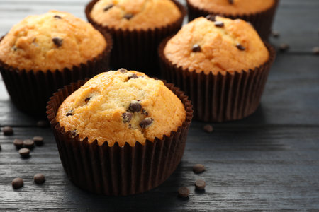 Delicious freshly baked muffins with chocolate chips on dark gray table, closeupの写真素材