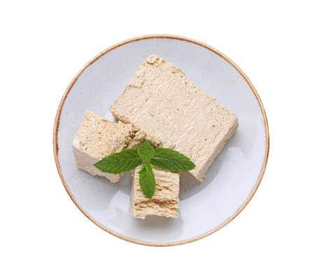 Plate with pieces of tasty halva and mint isolated on white, top viewの写真素材