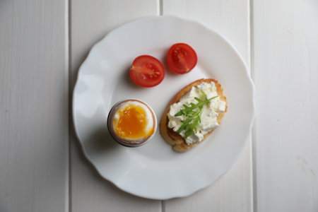 Breakfast with soft boiled egg on white wooden table, top viewの写真素材