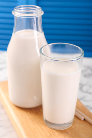 Glassware with tasty milk on white table, closeupの写真素材