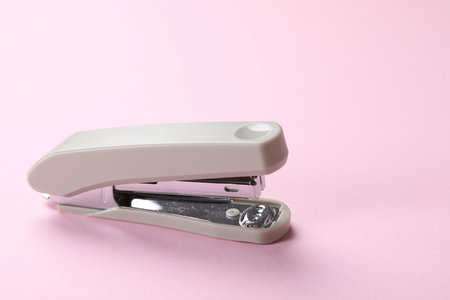 Beige staple on pink background, space for textの写真素材