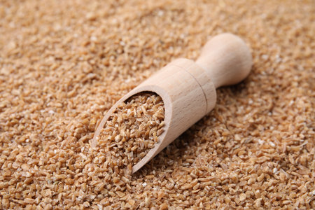 Wooden scoop with dry wheat groats, closeupの写真素材