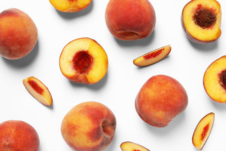 Cut and whole fresh ripe peaches on white background, flat lay