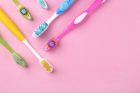 Many different toothbrushes on pink background, flat lay. Space for textの写真素材