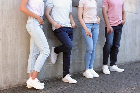 Group of people in stylish jeans near gray wall outdoors, closeupの写真素材