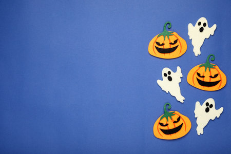 Pumpkins and ghosts on blue background, space for text. Halloween celebrationの写真素材