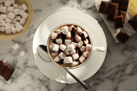 Cup of aromatic hot chocolate with marshmallows served on light marble table, flat layの写真素材