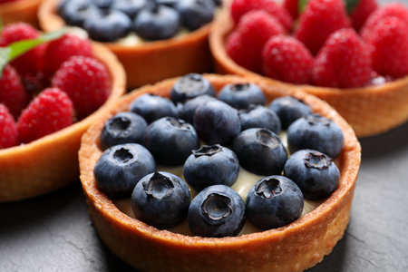 Tartlet with fresh blueberries on black table, closeup. Delicious dessertの写真素材