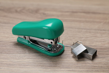 Turquoise stapler and staples on wooden table