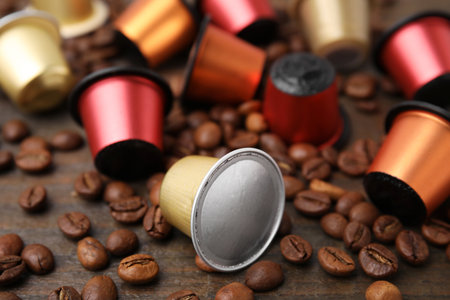 Many coffee capsules and beans on wooden table, closeupの写真素材
