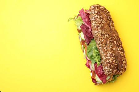 Delicious sandwich with schnitzel on yellow background, top view. Space for textの写真素材
