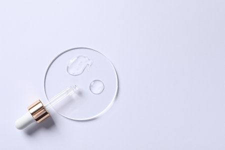 Samples of cosmetic serum and pipette on white background, top view. Space for textの写真素材