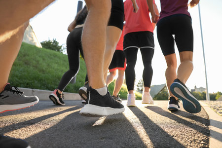Group of people running outdoors on sunny day, closeupの写真素材