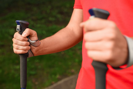 Man practicing Nordic walking with poles outdoors, closeupの写真素材