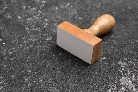 One stamp tool on dark textured table, closeup. Space for text