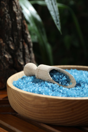 Bowl of blue sea salt with scoop on wooden table, closeupの写真素材