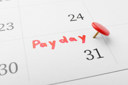 Calendar page with red pin on payday date, closeupの写真素材