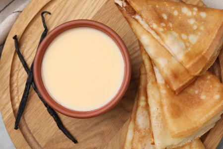 Tasty crepes served with condensed milk on table, flat layの写真素材