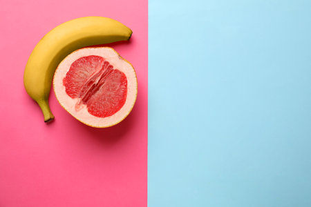Banana and half of grapefruit on color background, flat lay with space for text. Sex conceptの写真素材