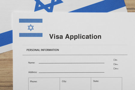 Immigration to Israel. Visa application form and flag on wooden table, top viewの写真素材