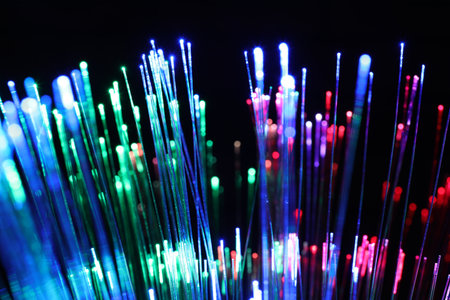 Optical fiber strands transmitting different color lights on black background, closeupの写真素材
