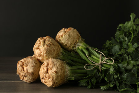 Fresh raw celery roots on wooden table, closeup. Space for text