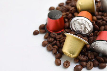 Many coffee capsules and beans on white table, closeup. Space for textの写真素材