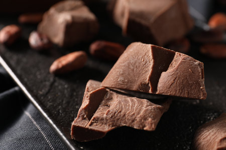 Pieces of tasty milk chocolate on slate board, closeupの写真素材
