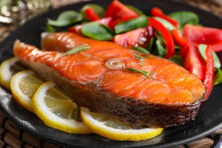 Healthy meal. Tasty grilled salmon with vegetables and lemon on plate, closeupの写真素材