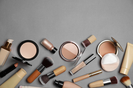 Face powders and other makeup products on gray background, flat lay. Space for textの写真素材