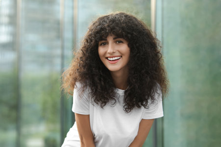 Portrait of beautiful woman posing on blurred background. Attractive lady smiling and looking into...