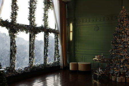 Beautiful Christmas tree and windows decorated with garlands and lights indoors. Interior designの写真素材