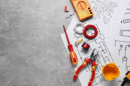 Flat lay composition with wiring diagrams and digital multimeter on gray table, space for textの写真素材