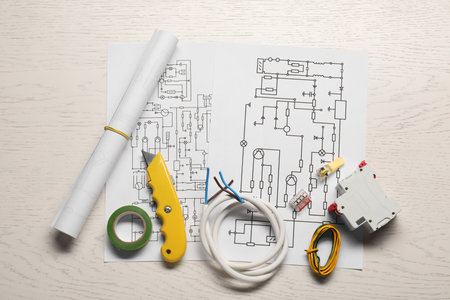 Wiring diagrams, knife, insulating tape, wires and switch on white wooden table, top viewの写真素材