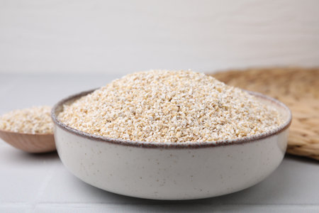 Raw barley groats in bowl on light table, closeupの写真素材
