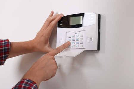 Man entering code on security alarm system at home, closeupの写真素材