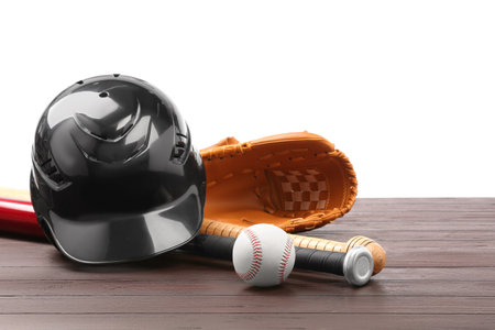 Baseball glove, bats, ball and batting helmet on wooden table against white backgroundの写真素材
