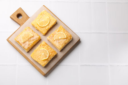 Tasty lemon bars on white tiled table, top view. Space for textの写真素材