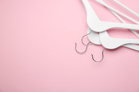 White hangers on pink background, top view. Space for textの写真素材