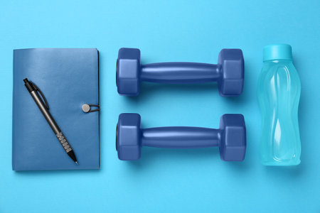 Flat lay composition with dumbbells on light blue backgroundの写真素材