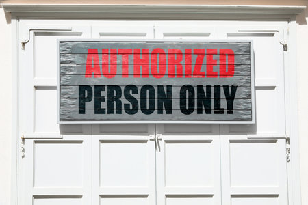 Board with text Authorized Person Only on white shutters garage door outdoorsの写真素材