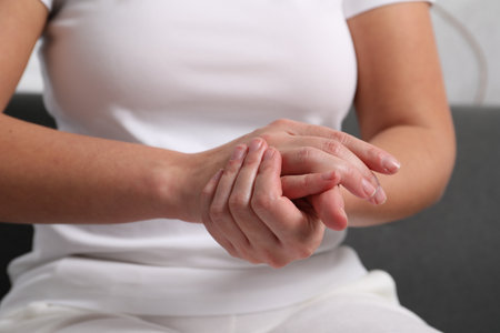 Woman applying cosmetic cream onto hand on blurred background, closeupの写真素材