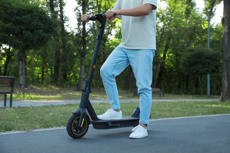 Man with modern electric kick scooter in park, closeupの写真素材