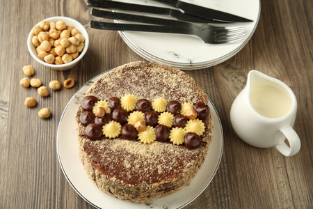 Delicious Kyiv Cake with cream and hazelnuts served on wooden tableの写真素材