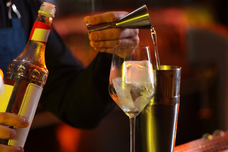 Bartender making fresh alcoholic cocktail against blurred background, closeupの写真素材