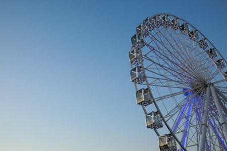 Big Ferris wheel against light blue sky, low angle view. Space for textの写真素材