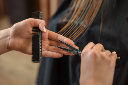 Professional hairdresser cutting girl's hair in beauty salon, closeupの写真素材