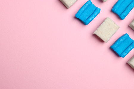 Different tasty colorful bubble gums on pink background, flat lay. Space for textの写真素材