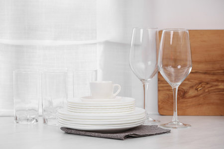 Clean dishes on light table in kitchenの写真素材