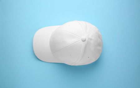 Stylish white baseball cap on light blue background, top viewの写真素材